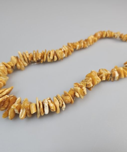 Balto gintaro kolje karoliai prie kaklo